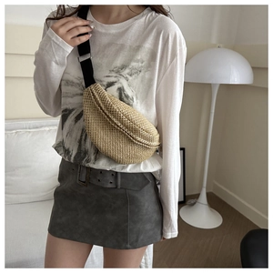 Vue détaillée du sac banane en paille tressée avec texture et sangle noire réglable