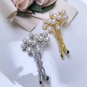 Detailed close-up of gold and silver pearl brooches with rose shell design elements