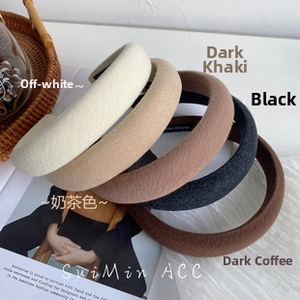 Detailed top view of wide sponge headbands in five neutral colors stacked on a table