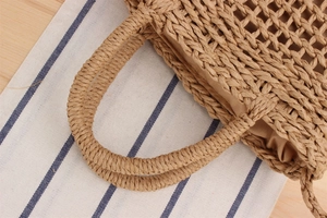 Detail of woven paper rope handle and texture on a summer beach crossbody bag