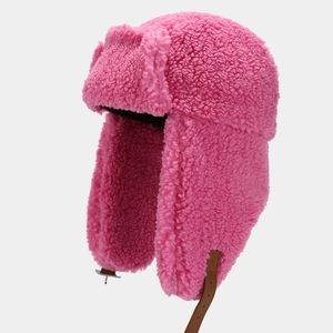 Detailed view of pink faux lamb wool trapper hat with brown leather chin strap and buckle