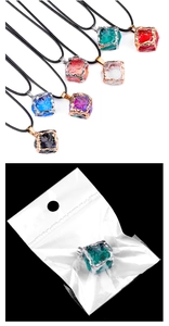 Collection of colorful crystal cube pendants and a green one in OPP packaging