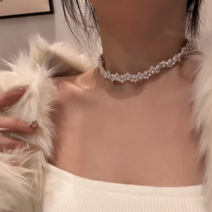 Close-up of pearl and zircon woven flower necklace on model's neck for elegant look