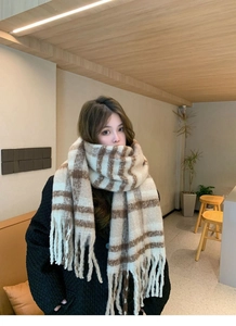 Detailed close-up of beige and brown plaid scarf featuring long soft tassels and mohair texture