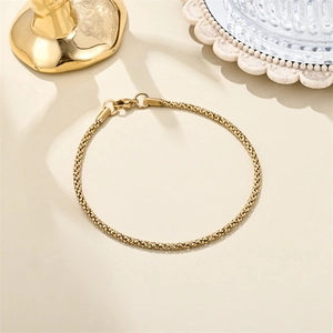 Detailed close-up of 18K gold stainless steel bracelet with intricate woven texture links