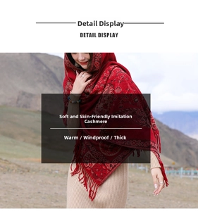Dettaglio dello scialle rosso in finta cashmere con motivi paisley e nappe di frangia