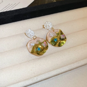 Close-up of vintage resin floral earrings with pink green gradient and blue crystals