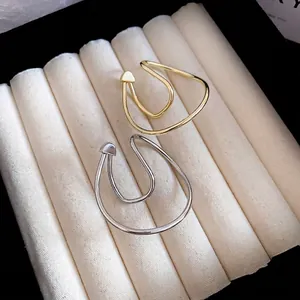 Minimalist twisted gold and silver metal ear cuff set with irregular double-line design