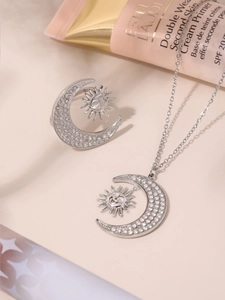 Detail of silver sun and crescent moon jewelry set featuring sparkling zircon stones