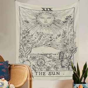 Detail eines Tarot-Wandteppichs Die Sonne über einem Korbsessel im Boho-Zimmer