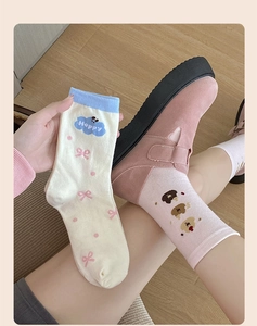 Close-up of cotton mid-calf socks with cute cartoon bear pattern and pink bow detail