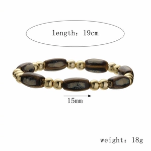 Détail du bracelet perlé avec perles cylindriques marron marbré et entretoises dorées