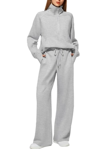Women's grey two-piece set featuring a half-zip sweatshirt and wide-leg joggers on model