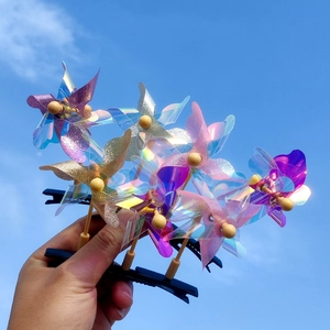 Pince à cheveux moulin à vent pailleté avec effet laser sur fond de ciel bleu clair