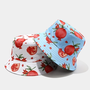 Detail of reversible bucket hats featuring red pomegranate prints in white and light blue