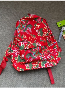 Detailed shot of traditional Chinese floral print backpack with red nylon straps and zippers
