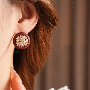 Close-up of vintage dark red matte oval earrings with baguette-cut crystal center