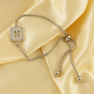 Minimalist adjustable silver stainless steel bracelet featuring a hollow letter N pendant