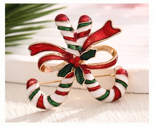 Detail of candy cane Christmas brooch with red bow, holly leaves and shiny rhinestones