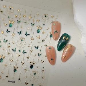 Macro detail of gold butterfly and star moon nail stickers Co-465 on finished nails