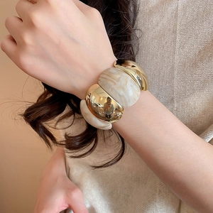 Close-up of wide acrylic marble stretch bracelet with gold-tone metal accents
