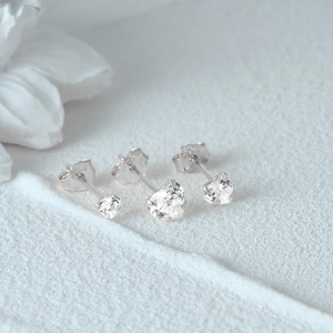 Detailed view of three pairs of S925 sterling silver heart stud earrings with cubic zirconia