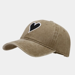 Close-up of heart embroidery patch on vintage washed cotton baseball cap texture