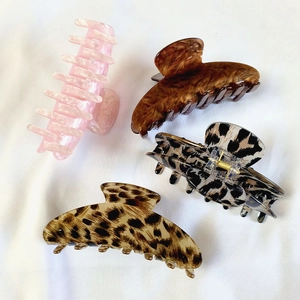 Set of four large acetate hair claw clips in marble, amber, leopard, and spotted patterns