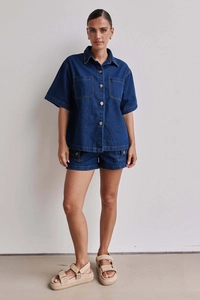 Details von dunkelblauem Jeanshemd mit Vintage-Holzknöpfen und passenden Cargo-Shorts