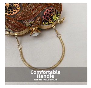 Detail shot of golden ring handle and colorful sequins on a vintage embroidery handbag