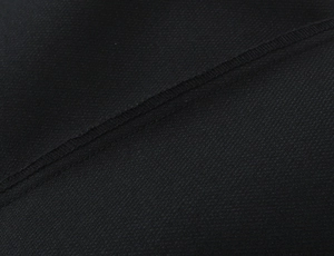 Macro view of black polka dot dress mesh fabric with durable flat seam stitching