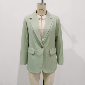 Detail view of mint green V-neck blazer with single dark button and flap pockets