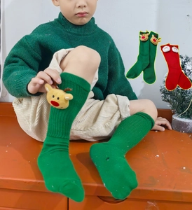 Detailansicht der festlichen Weihnachtssocken für Kinder mit 3D-Rentier- und Weihnachtsmann-Puppen