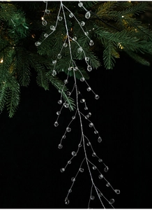 Detail of crystal bead garlands hanging on a Christmas tree with warm lights