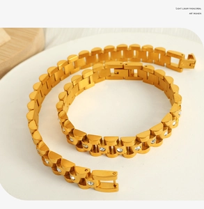 Detailed macro view of 18k gold-plated watch chain bracelet with white crystal inlays