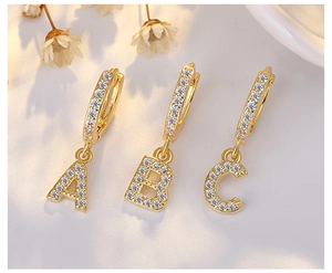 Close-up of gold S925 silver hoop earrings with micro-paved crystal A B C letters
