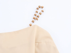 Detail eines Boho-Sommerkleides mit geflochtenen Trägern und Akzenten aus Holzperlen