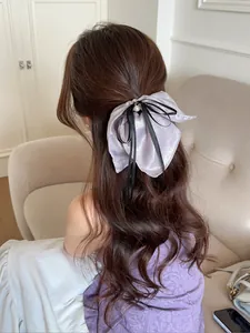Détail du chouchou nœud violet clair nacré avec perle et ruban noir élégant