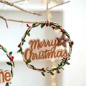 Round wooden Merry Christmas wreath with green leaves and red berries on hemp rope