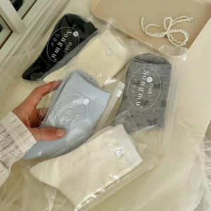 Détail de chaussettes en coton avec boutons décoratifs dans un style coréen raffiné