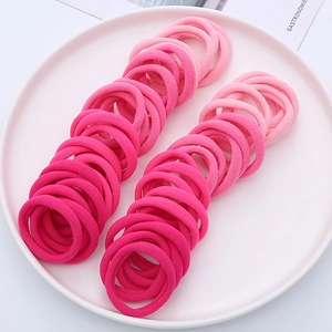 Detail of multi-toned pink seamless elastic hair ties arranged on a white tray