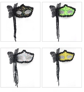 Detail of glitter party masks with lace butterflies and sequins in black green white and yellow