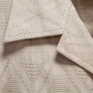 Close-up of beige jacquard summer shirt featuring detailed geometric triangle patterns