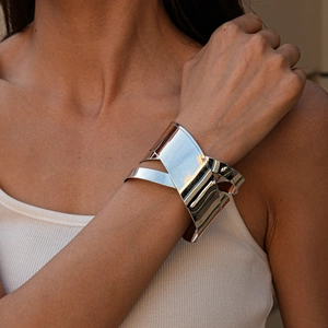 Vue rapprochée d'un bracelet large géométrique argenté à couches sur le poignet d'un mannequin