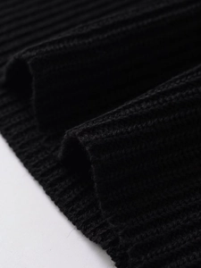 Detailed close-up showing the fine rib-knit texture and quality of the black knitted top