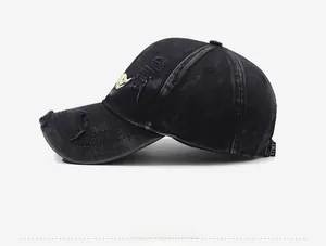 Close-up of vintage washed denim baseball cap with gold embroidery and side label