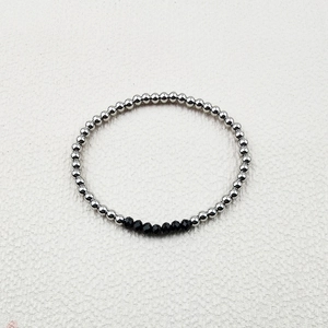 Detail of handmade elastic bracelet with silver steel beads and black faceted crystals