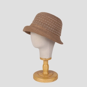 Macro detail of brown knitted linen bucket hat with white stripes and rolled brim design