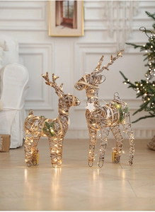 Close-up of lighted champagne iron reindeer statues with twine texture and warm LED lights