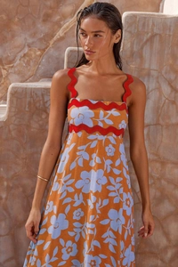 Detail showing orange floral dress with red ricrac trim and premium linen texture